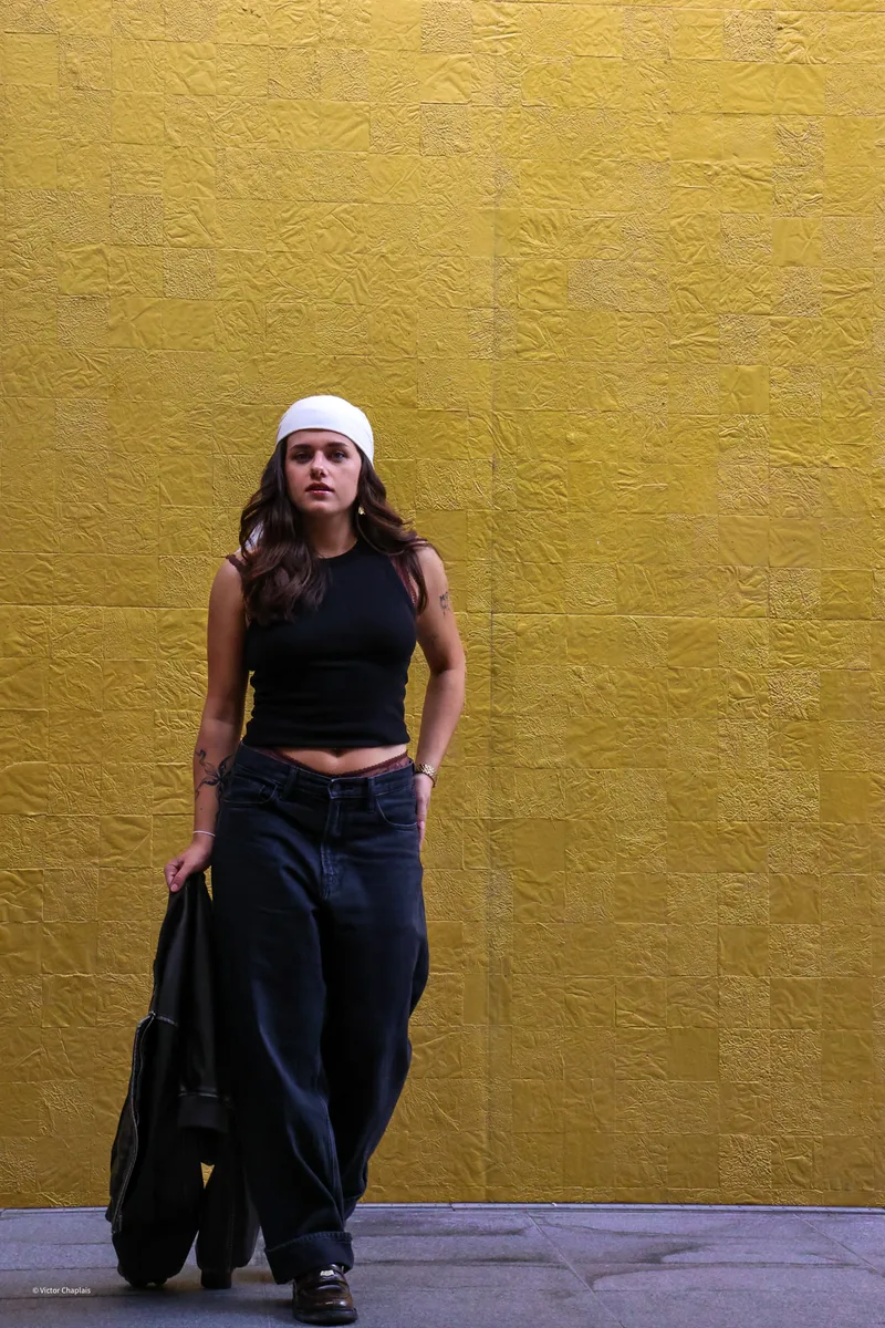 Mona, créatrice UGC, en shooting devant un mur jaune · l'incarnation des contenus de marque